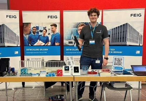 Person steht bei Jugend Forscht vor einem Tisch mit Payment-Terminals